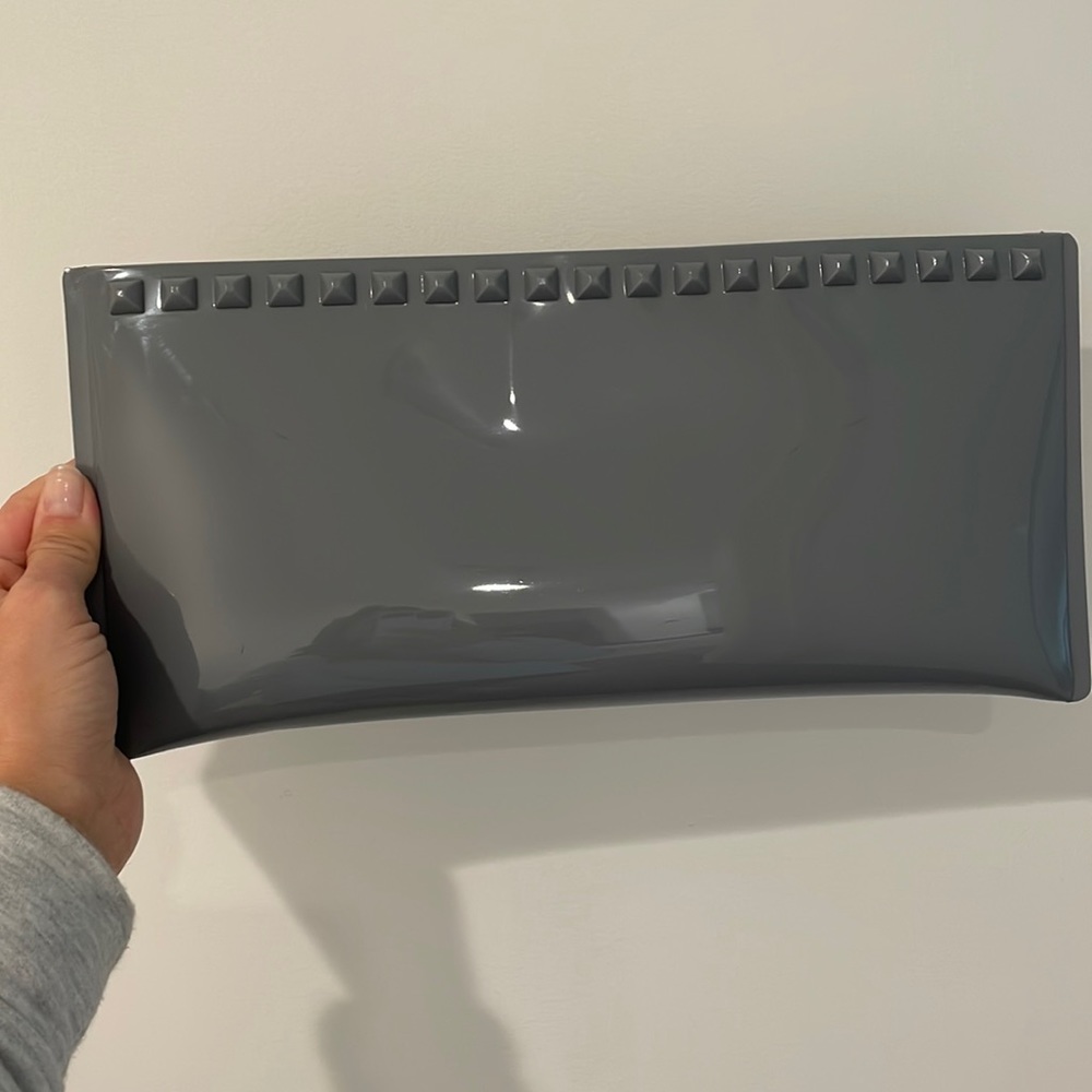 Carmen Sol Italian-made grey silicone clutch with grommets.